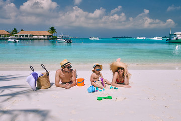 Fototapeta na wymiar Family on beach, young couple with three year old boy. Summer vacation at Maldives.