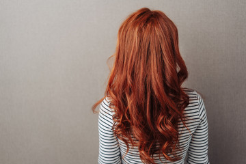 Rear view of a woman with long curly red hair