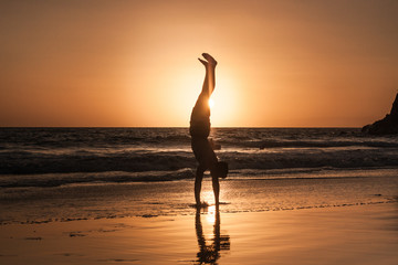 Equilibrios al borde del mar en un atardecer brillante