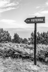 2,2 km to Fisterra distance sign from Cape Finisterre, Cabo Fisterra or Cabo Finisterre - the end of the Way of St. James, Camino de Santiago, Galicia, Spain, black and white photography