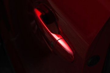 Close up of the door handle of a red car