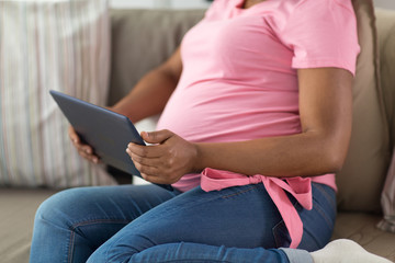 pregnancy, technology and people concept - close up of pregnant african american woman with tablet pc computer at home
