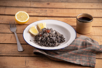Fototapeta na wymiar Plate of black rice with squid and prawns or Valencian black paella