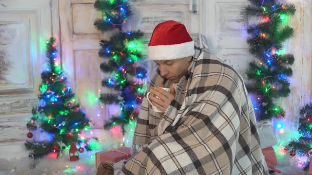 Man Covered Pleid In Santa Hat Drinking Coffee