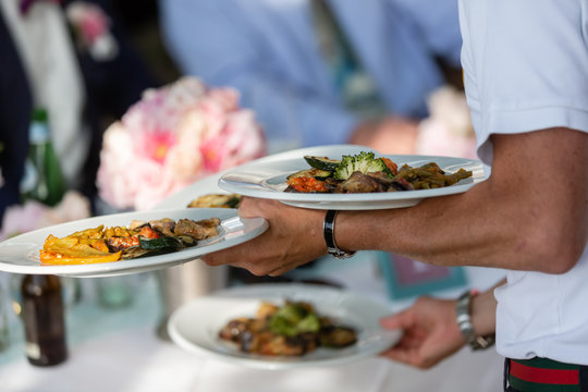 waiter serves Italian antipasti in an outdoor restaurant