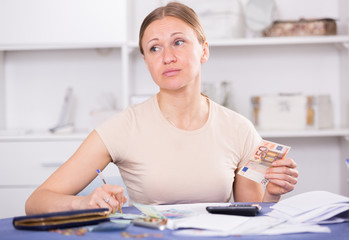Woman counting money for paying bills