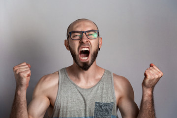 Emotions of anger and indignation. The man in glasses clenched his hands into fists and shouted....