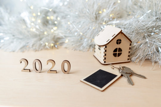 Concept for business, new year, real estate, property, rental, hotel business, building. 2020 happy new year wood number, wooden house and keys on the table