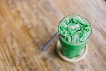 Iced green tea matcha in a glass cup on wood table