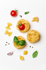 Various uncooked pasta on white background. Top view. Raw pasta with ingredients for cooking. Food concept