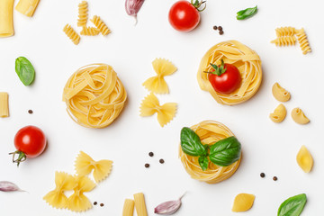 Various uncooked pasta on white background. Top view. Raw pasta with ingredients for cooking. Food concept