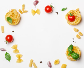 Various uncooked pasta on white background. Top view. Raw pasta with ingredients for cooking. Food concept