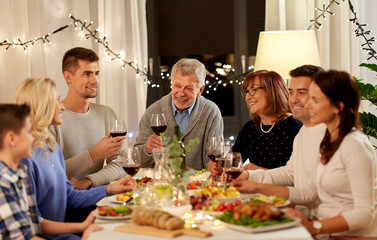 celebration, holidays and people concept - happy family having dinner party, drinking red wine and toasting at home