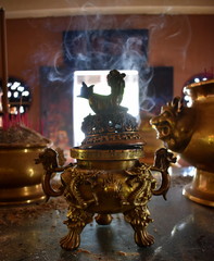 Golden incense burner smoking at a Chinese temple