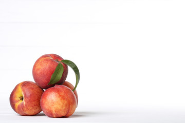 Fototapeta na wymiar Fresh peaches with green leaf on white background