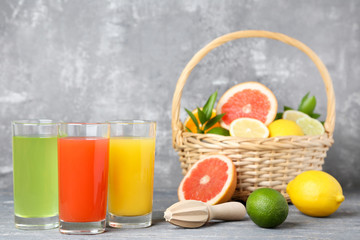 Citrus juice in glasses with fruits on wooden table