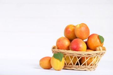 Sweet apricots in basket on white background