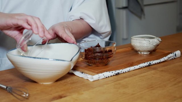 A Japanese female chef mixing the sause at home kitchen, Tokyo, Japan. May 2019. Camera fixed, Close-up, high angle.