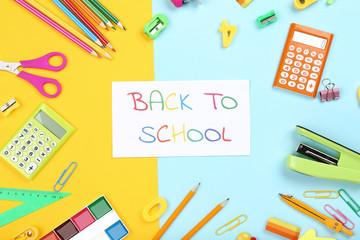 Text Back To School with stationery on colorful background