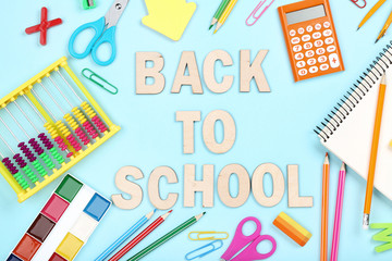 Text Back To School with stationery on blue background
