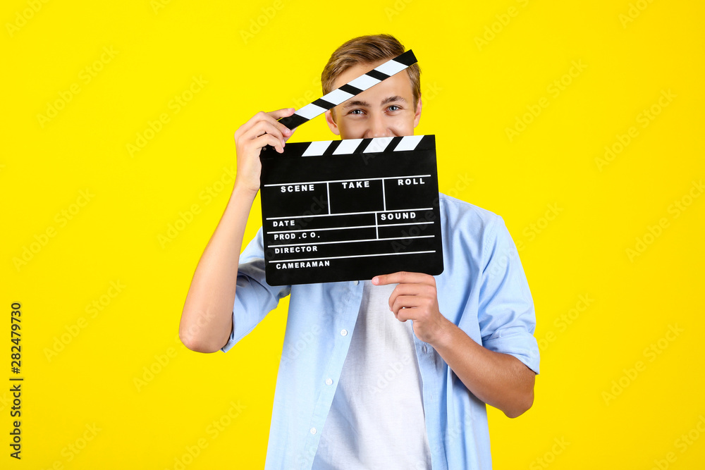 Sticker Young man with clapper board on yellow background