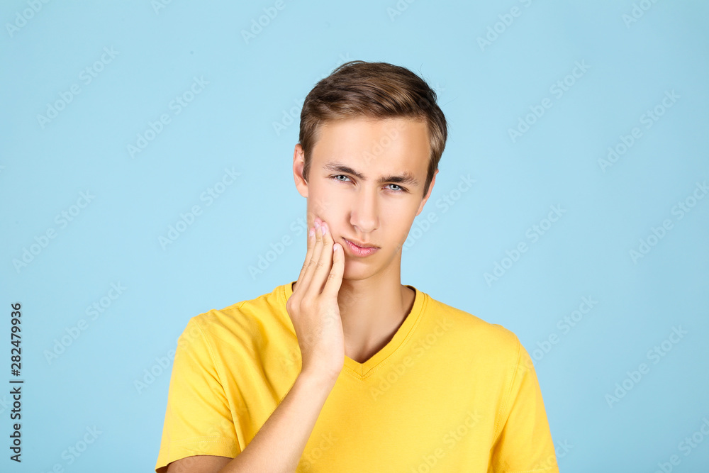 Canvas Prints Young man having toothache on blue background