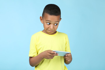 Cute american boy playing on mobile phone