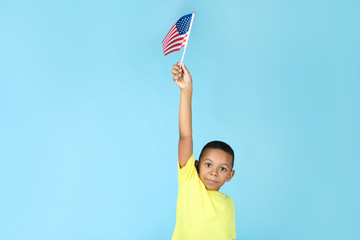 Cute boy with american flag on blue background