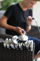 A young golfer cleans his golf clubs