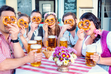 Group in Bavarian beer garden looking through pretzel holes