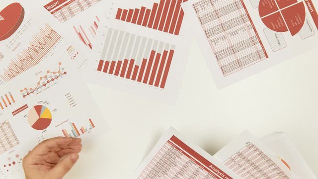 Businessman working and calculating, reads and writes reports. Office employee, table closeup. Business financial accounting concept.