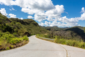 Beautiful view of  a  country road to Serra do Cipo in Minas Gerais with forests, clouds and mountains in sunny summer day with blue sky. Landscape of the Brazilian Cerrado, one of the most devastated