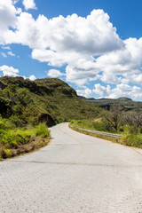 Beautiful view of  a  country road to Serra do Cipo in Minas Gerais with forests, clouds and mountains in sunny summer day with blue sky. Landscape of the Brazilian Cerrado, one of the most devastated