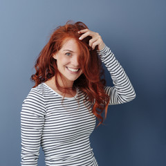 Attractive smiling young woman with long red hair