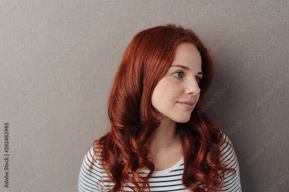 Wall mural thoughtful young woman with long red hair