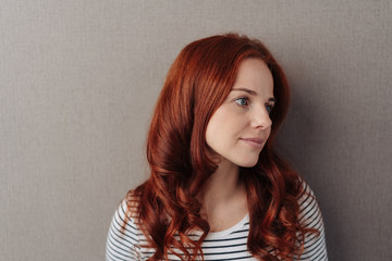 Thoughtful young woman with long red hair