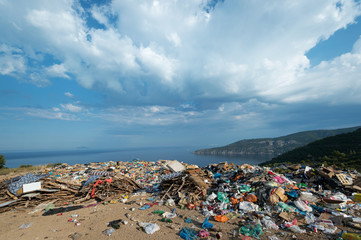 Piles of waste at landfill next to sea. Bad waste management, ecology, enviromental issues concept