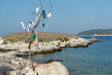 Marine debris accumulates heavily along seashores. Plastic bottles and other garbage on disposal. Plastic waste tide, sea pollution.