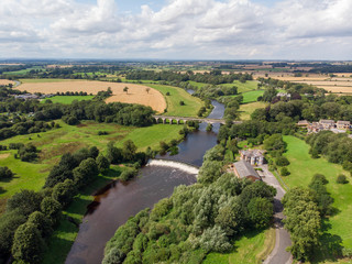 Fototapeta na wymiar Aerial photo of the the historic Tadcaster Viaduct and River Wharfe located in the West Yorkshire British town of Tadcaster, taken on a bright sunny day
