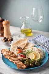 assorted greek food platter with souvlaki, rice, pita and dolmades