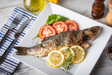 greek style grilled sea bass on rustic background