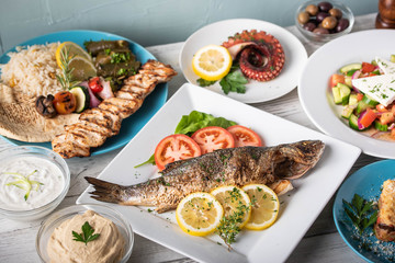assorted popular greek plates on rustic wooden background