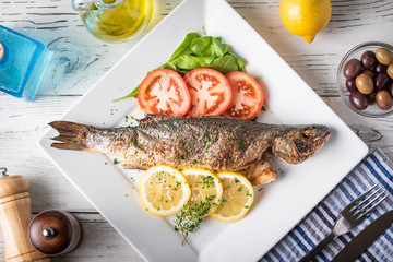 greek style grilled sea bass on rustic background