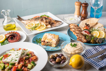 Fototapeta na wymiar assorted popular greek plates on rustic wooden background