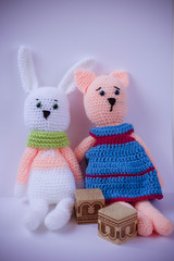 crochet toy pink cat in a dress and a white hare