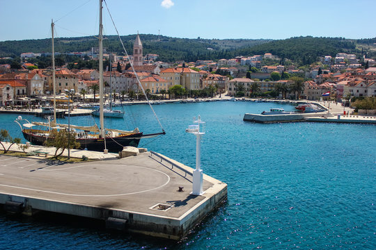 Supetar on Brac Island, Croatia. Arriving by Ferry from Split. Panoramic view on the harbor from the side of the sea on a clear blue sky day.