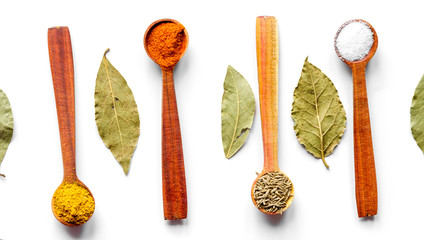 spices in wooden spoons on white background top view