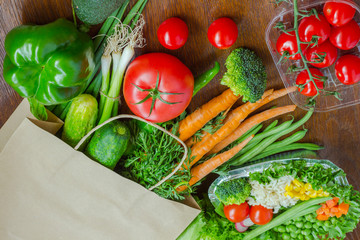 Healthy food in full paper bag of different products, vegetables. Top view. Food background