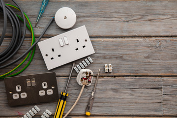 Electrical tools and equipment on a wooden background
