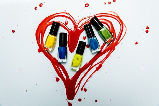 multicolored nail polishes on a red heart background